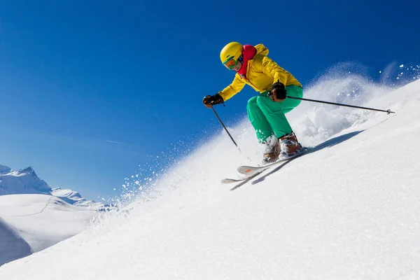 女子滑雪在雪山山坡上明亮的滑雪服 头盔和谷歌 — 图库照片