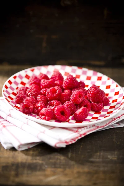 Teller Mit Frischen Himbeeren Auf Küchentuch Auf Dunklem Holz — Stockfoto