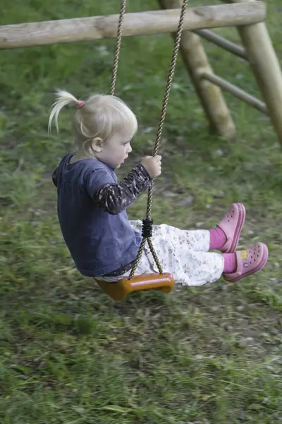 Menina jogando no balanço — Fotografia de Stock