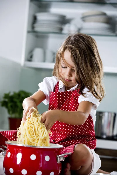 Девушка играет со спагетти — стоковое фото
