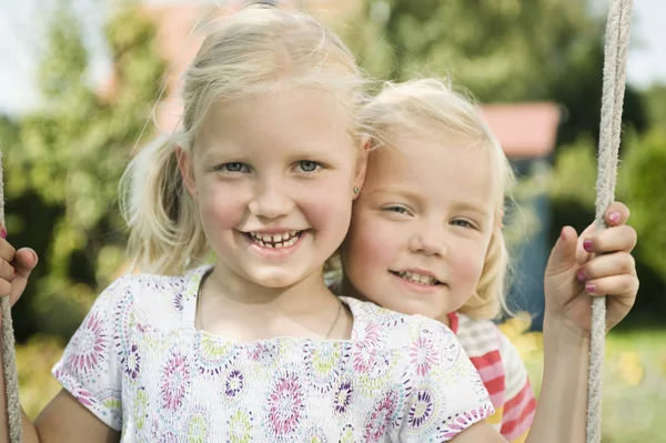 Girls swinging on swing — Stock Photo, Image