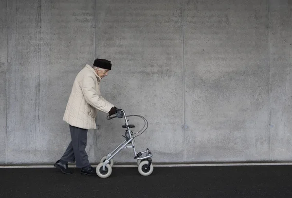 Senior woman walking with wheeled walker — Stock Photo, Image