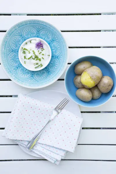 Bowl of jacket potatoes and bowl of curd — Stock Photo, Image