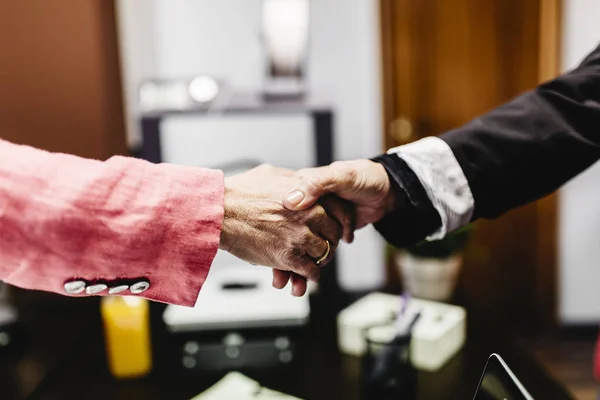 Close-up of two businesswomen shaking hands in office — Stock Photo