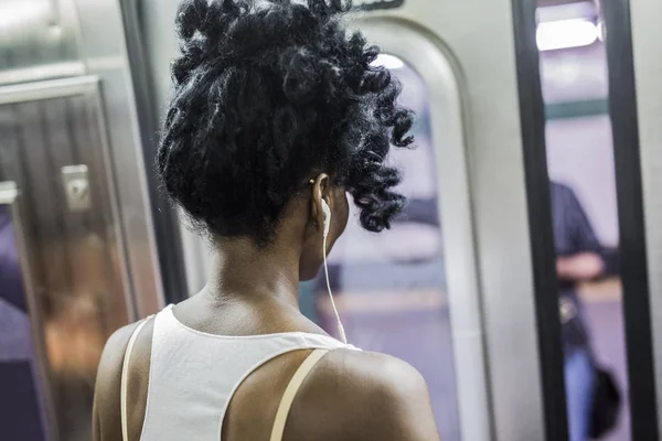 Retrato recortado de mulher com fones de ouvido em pé no trem do metrô — Fotografia de Stock