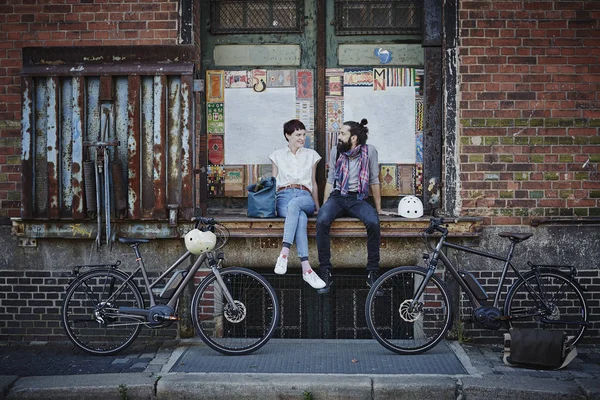 Портрет пары, отдыхающей на строительстве рядом с велосипедами — стоковое фото