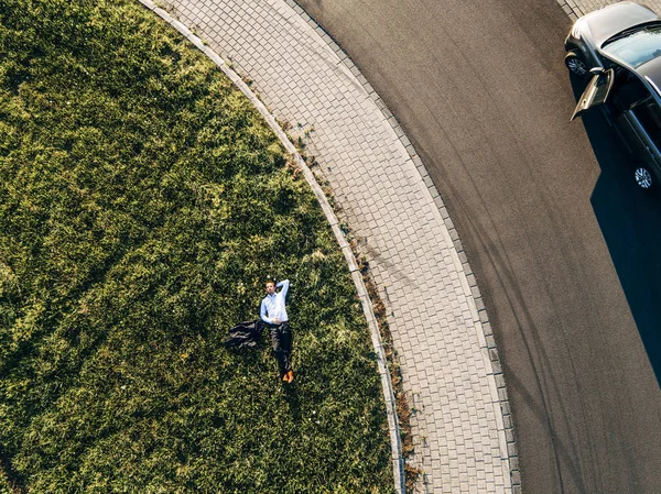 Homme d'affaires couché sur l'île de la circulation dans le rond-point — Photo de stock