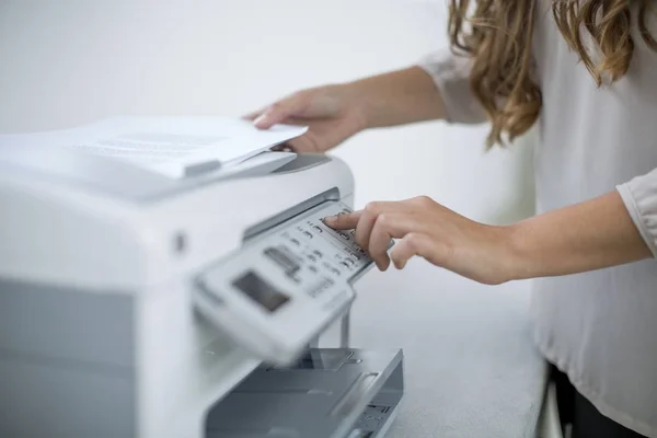 Mains féminines en utilisant l'imprimante dans le bureau — Photo de stock