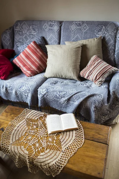 Sofá com almofadas e guardanapo na mesa de café — Fotografia de Stock