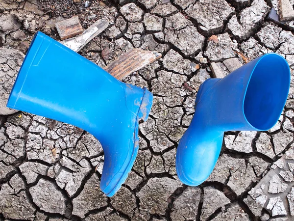 Blauwe laarzen op dorre gebied — Stockfoto