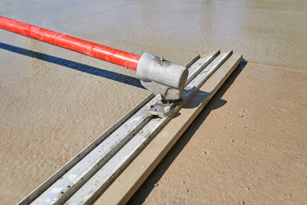 Arbetaren screeding cement golv med bull float — Stockfoto