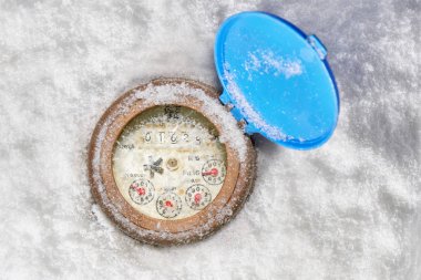 Broken glass on water meter clock in the snow- below zero clipart