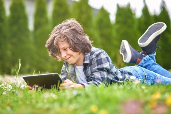 Tiempo Libre Niño Usando Tableta Digital Mientras Está Acostado Jardín Imagen de archivo
