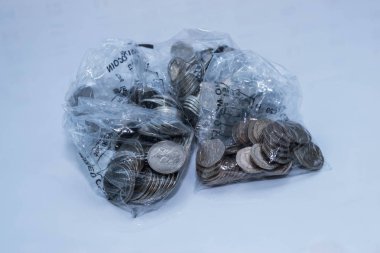 Beyaz bir arka planda plastik torbalar toplama banka coing İngiliz paraları.