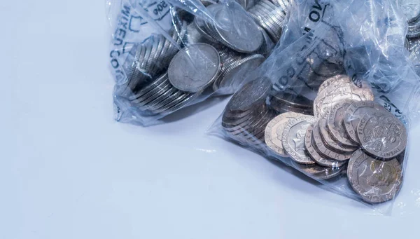 Brit érmék banki Coing gyűjtése műanyag zacskók fehér alapon. — Stock Fotó