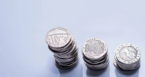 Pilhas de diferentes moedas britânicas em um fundo branco . — Fotografia de Stock