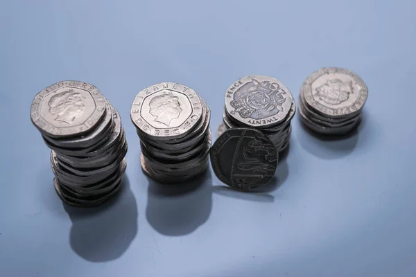 Pilhas de diferentes moedas britânicas em um fundo branco . — Fotografia de Stock