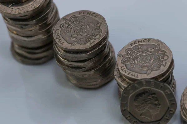 Pilhas de diferentes moedas britânicas em um fundo branco . — Fotografia de Stock