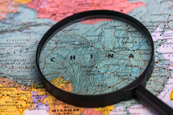 Map of china through magnifying glass on a world map.