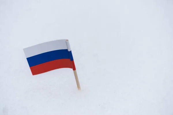 Drapeau de Russie en papier avec cure-dents marron sur fond de neige blanche . — Photo