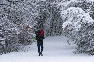 Baba küçük kızı orman Park yoğun kar yağışı sırasında taşıma