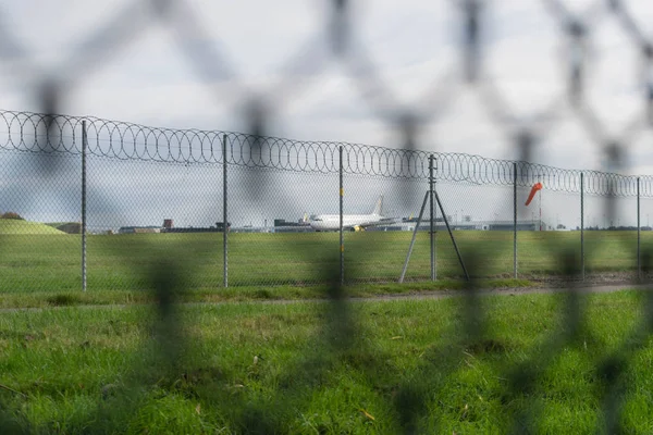 Birmingham International Airport, Birmingham, Storbritannien - 28 oktober 2017: planet landar i airfield omgiven av staket och varningsskyltar för säkerhet. — Stockfoto