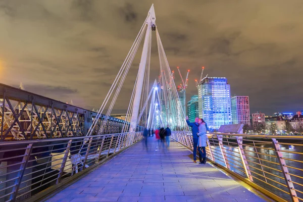 London, United Kingdom, February 17, 2018: long exposure of people walking and taking photos on Queens Golden Jubilee Footbridges near Charring Cross station — Stock Photo, Image