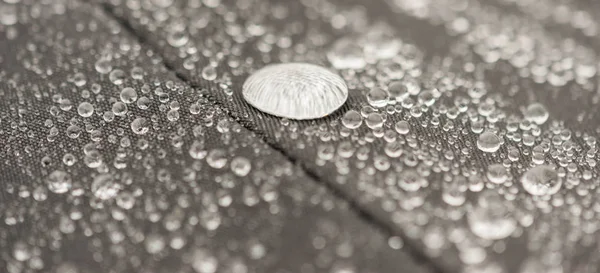 Closeup detailed view of raindrops on a fabric, a background.