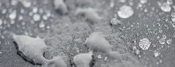 Primo piano vista dettagliata di gocce di pioggia su un tessuto, uno sfondo . — Foto Stock