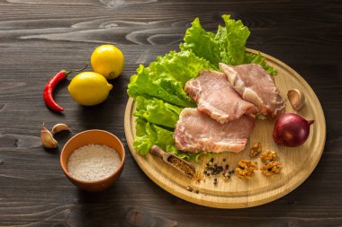 Çiğ et dilimleri. Domuz eti escalope ahşap oyun tahtası.