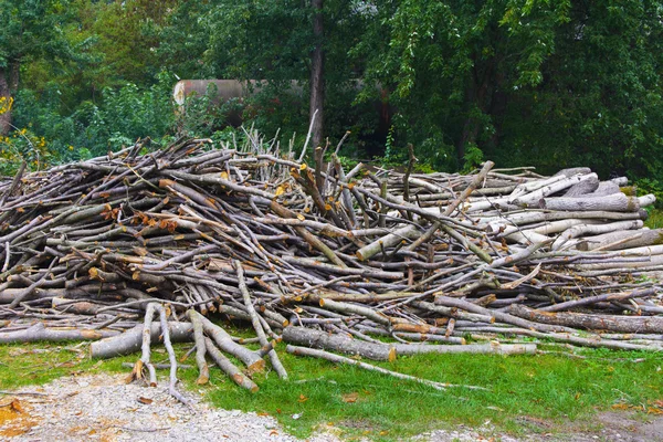 Brandhout bedolven onder een berg in een veld in de buurt van het huis — Stockfoto
