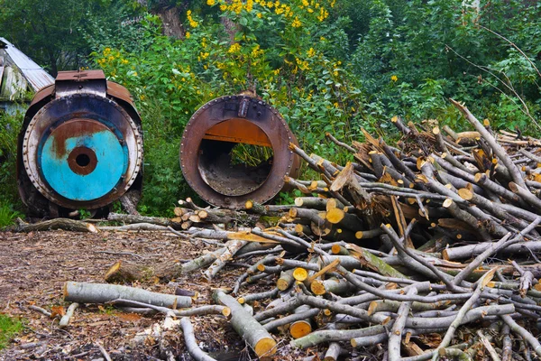 A lenha empilhou um montão em um campo perto da casa — Fotografia de Stock