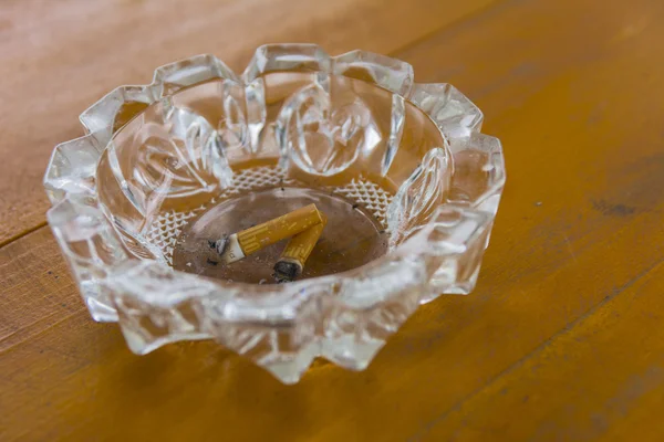 Cinzeiro sujo com pontas de cigarro na mesa — Fotografia de Stock