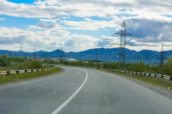 Camino de montaña. El paisaje de campos y montañas —  Fotos de Stock