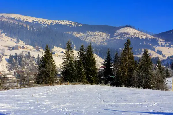 Pueblo de montaña en invierno nevada entre las montañas — Foto de Stock