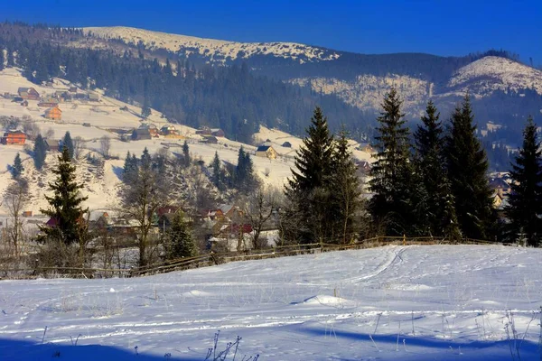 Pueblo de montaña en invierno nevada entre las montañas — Foto de Stock