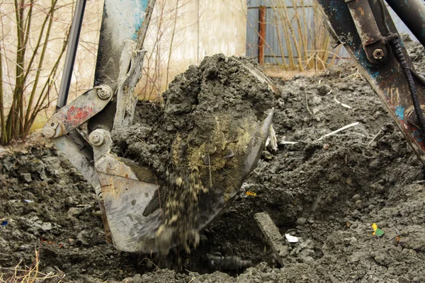 Een oude Sovjet-Unie trekker graaft en ladingen afvalstoffen steen verwerking in de buurt van — Stockfoto