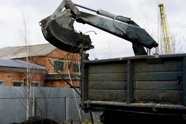 Een oude Sovjet-Unie trekker graaft en ladingen afvalstoffen steen verwerking in de buurt van — Stockfoto