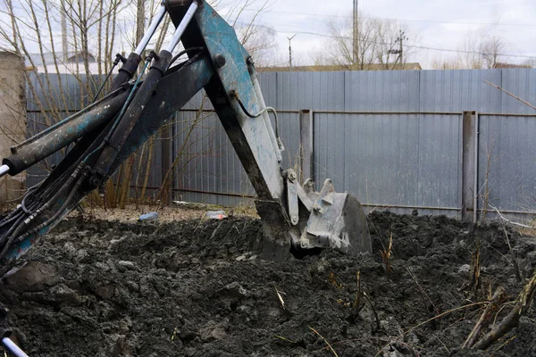 Un viejo tractor soviético excava y carga residuos de procesamiento de piedra cerca —  Fotos de Stock