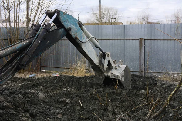 Egy régi szovjet traktor ás, és betölti a hulladék kő feldolgozás közelében — Stock Fotó