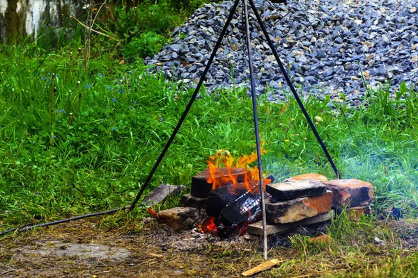 Gotowanie na ogniu na świeżym powietrzu, ogień, stanąć na obsługuje trzy — Zdjęcie stockowe