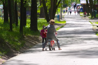 Dabushka ve torunu şehir parkta Bisiklete binmek. 