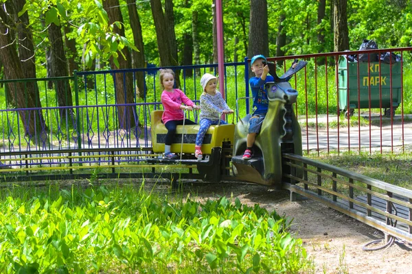 Dzieci jeździć na karuzeli na plac zabaw dla dzieci — Zdjęcie stockowe