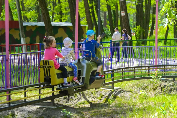 Dzieci jeździć na karuzeli na plac zabaw dla dzieci — Zdjęcie stockowe