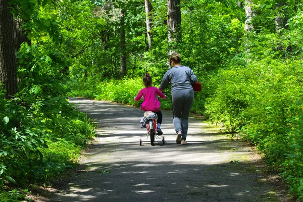 Dabushka ve torunu şehir parkta Bisiklete binmek. Mayıs 