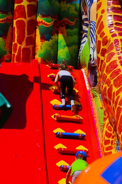 Kinder spielen auf dem aufblasbaren Kinderspielplatz in der Stadt — Stockfoto