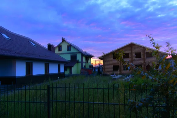 Private houses in the village at sunset. Beautiful night sky. Au