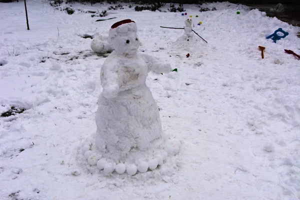 休暇と白と汚れた雪の背景とお祭り気分の日に個人の家の冬の中庭で子どもたちが作ったひどいと醜い雪だるま — ストック写真