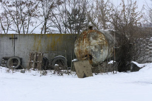 冬の白い雪を背景に放棄し 破壊された工場で牛乳を収集するための大規模な古いタンク 破壊や破壊行為 ウクライナ — ストック写真