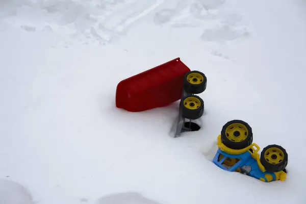 A pair of children's toy cars thrown on the snow by children aga — Stock Photo, Image